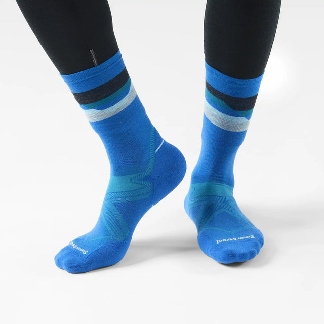 Smartwool Horizons men's merino wool running crew sock in lagoon blue with mountain range motif, worn with running tights