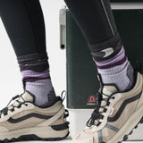 Smartwool Lunar Trek women's merino wool hiking crew sock in purple eclipse with loon and moon motif, worn with sneakers