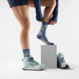 Smartwool Otter Float women's merino wool hiking crew sock in dusk blue with otter motif, worn with hiking boots